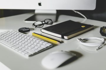 A workstation with a keyboard, notebook, and accessories.