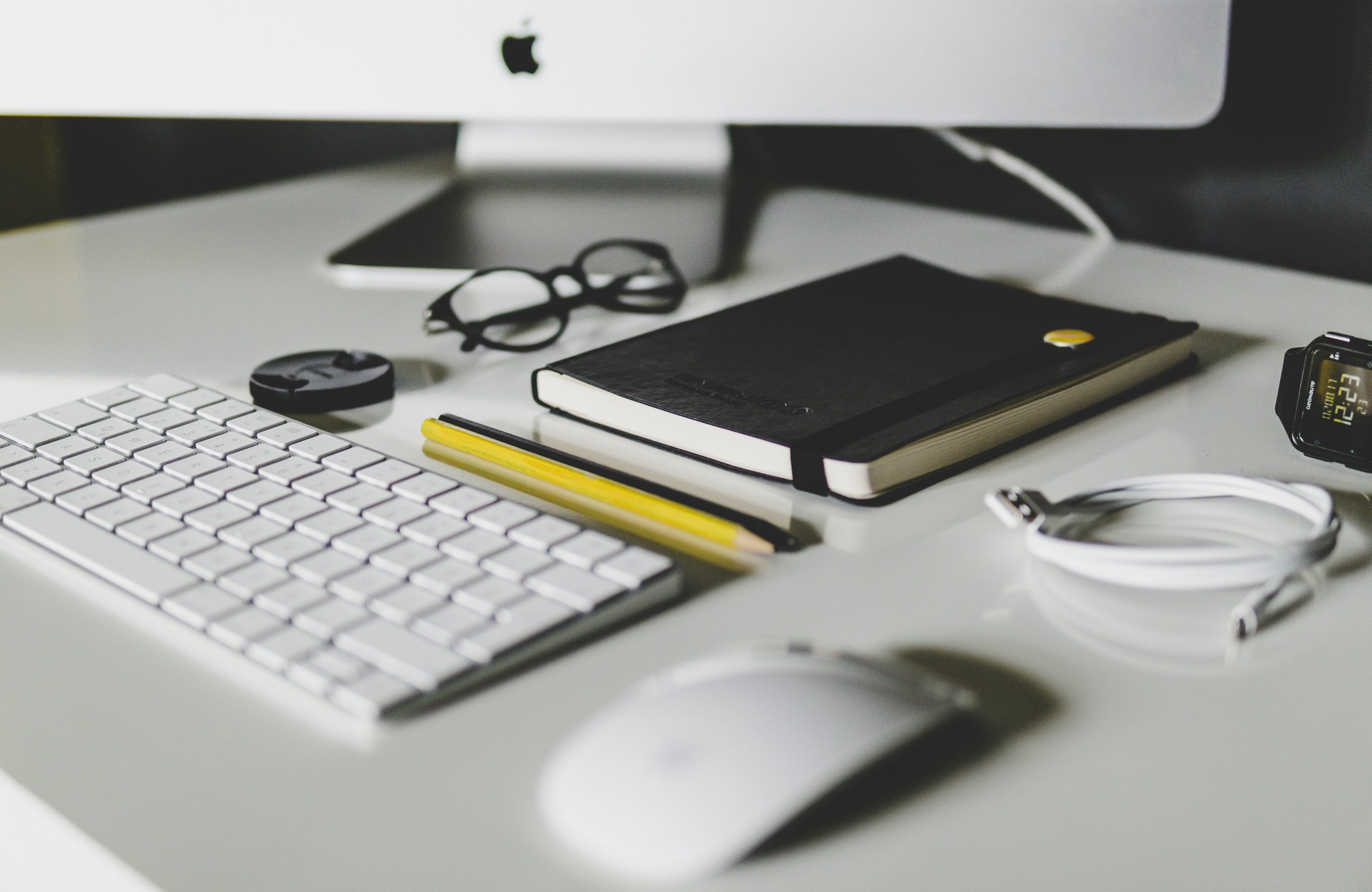 A workstation with a keyboard, notebook, and accessories.