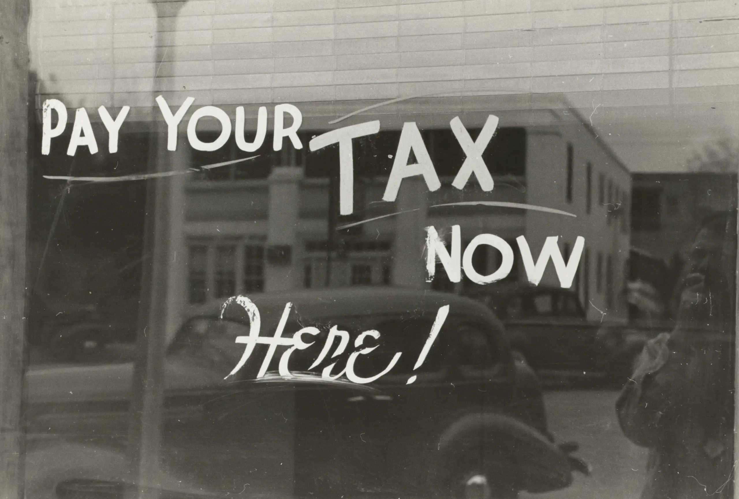 A signboard saying “Pay Your Tax Now.”