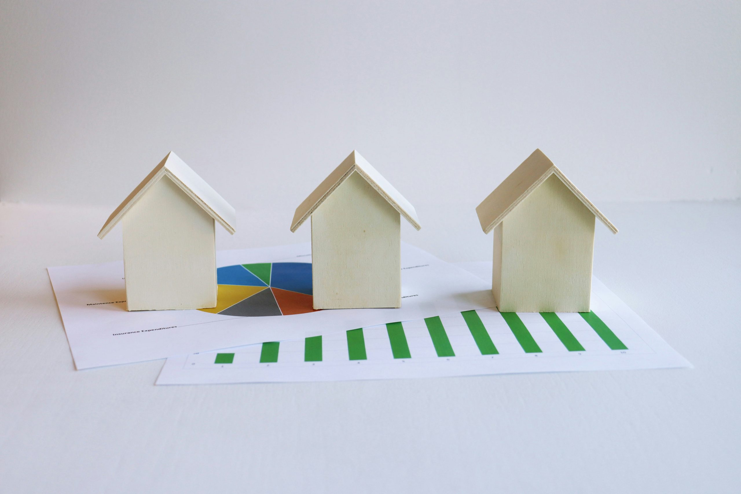 Paper models of houses with financial charts.