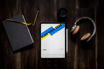 A digital tablet with tax-related notes on a dark wooden desk.