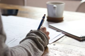 A person using a calculator while taking notes.