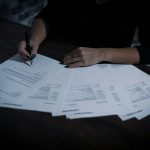 A person reviewing financial documents at a desk.