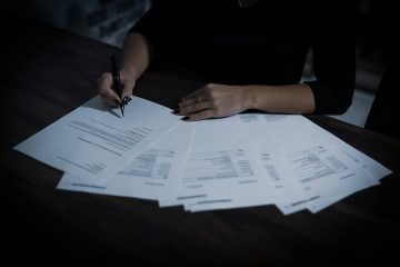 A person reviewing financial documents at a desk.