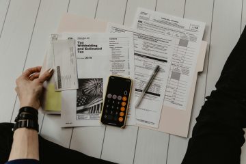 A person calculating withholding tax with a pen and calculator.